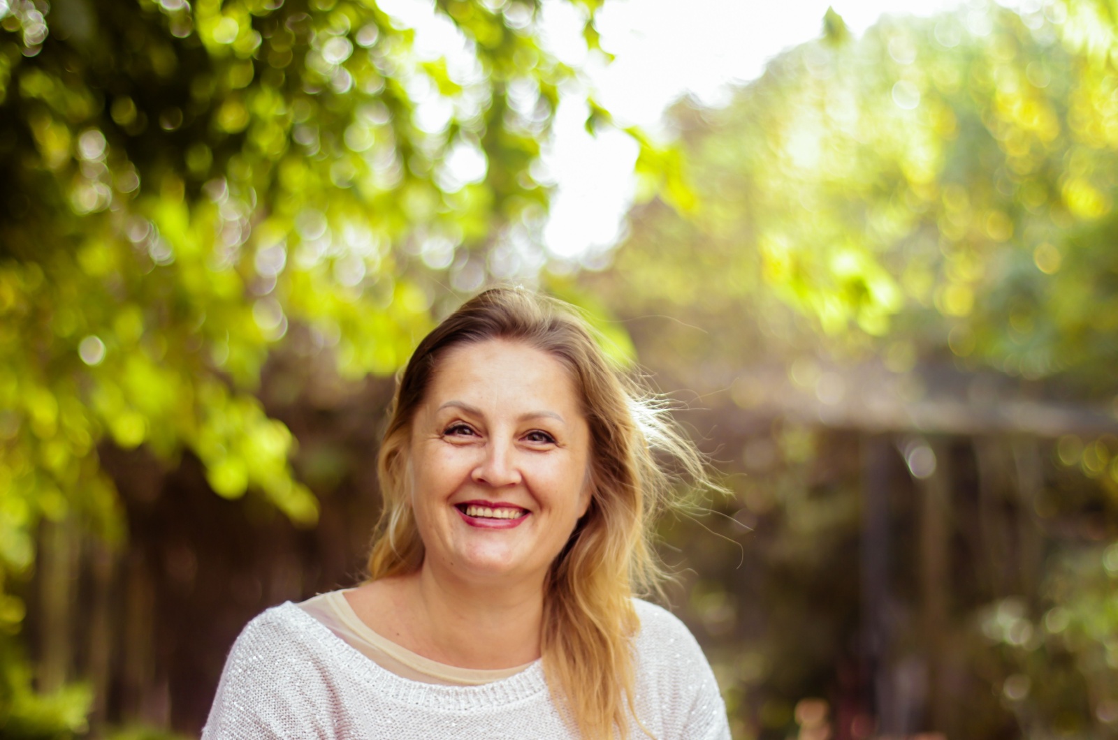 Frau ueber 40 laechelnd im Garten
