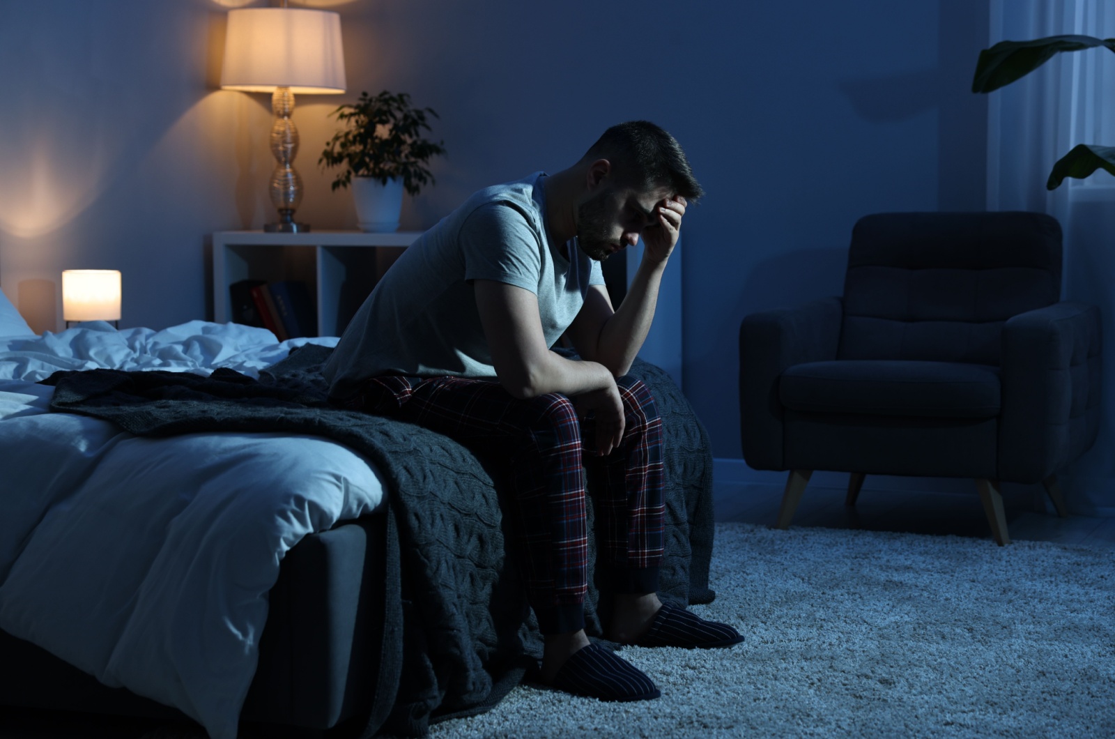 Mann denkt auf einem Bett nach