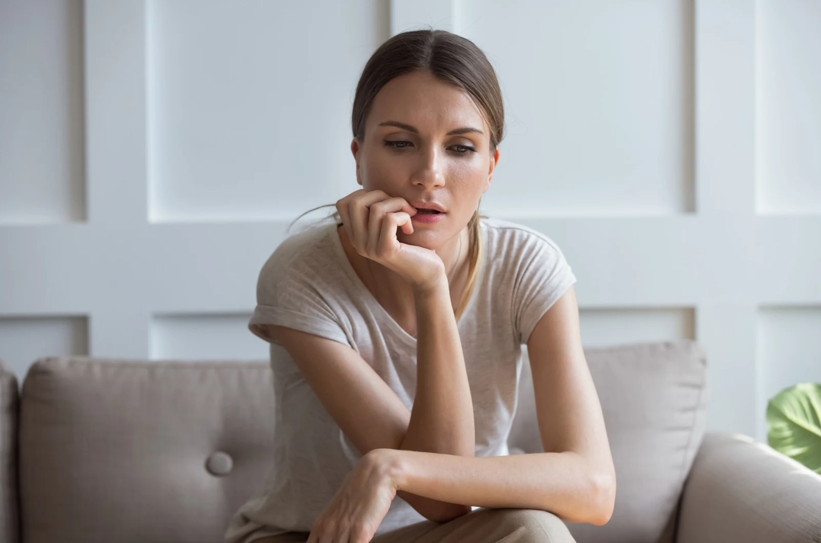 traurige Frau sitzt auf der Couch
