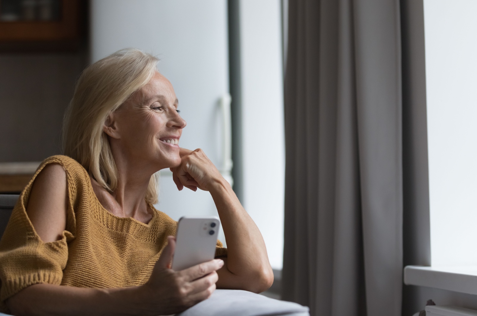 Frau ueber 60 haelt ein Telefon