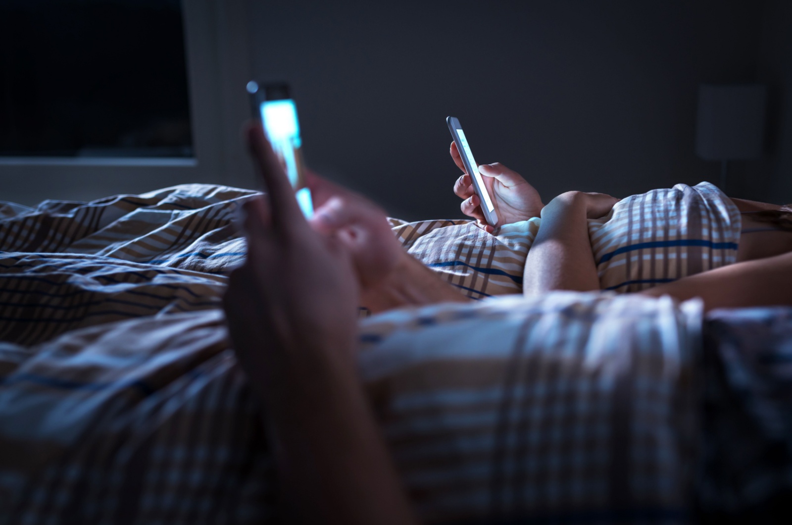 Paar mit Telefon im Bett