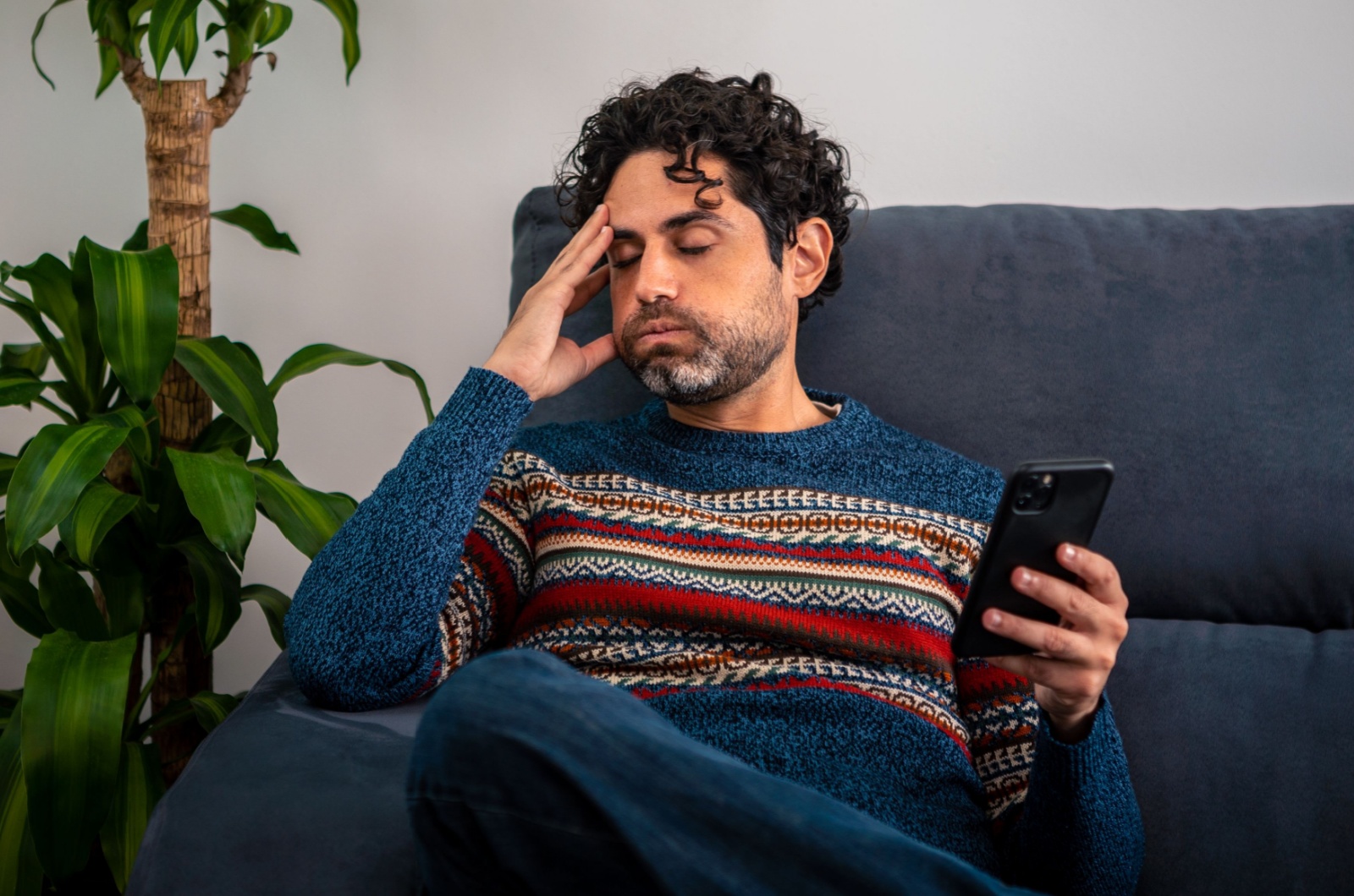 besorgter Mann haelt ein Telefon