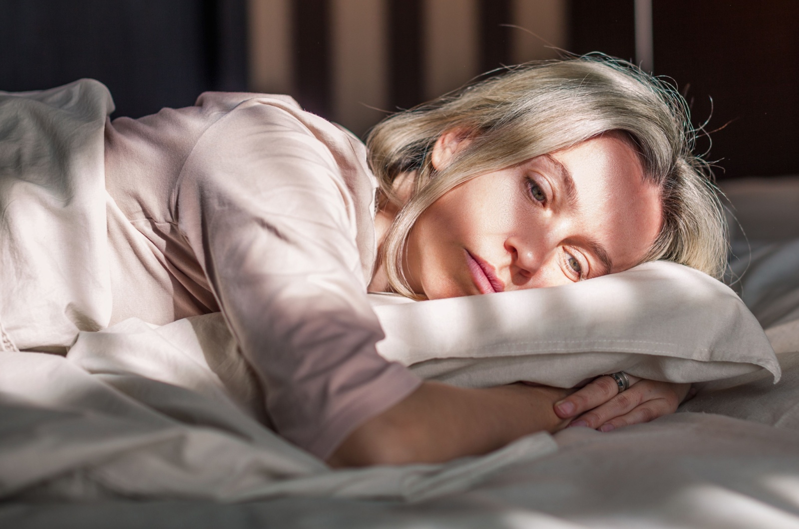 traurige Frau liegt im Bett