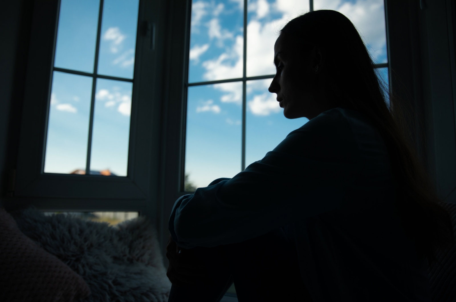 traurige Frau sitzt am Fenster