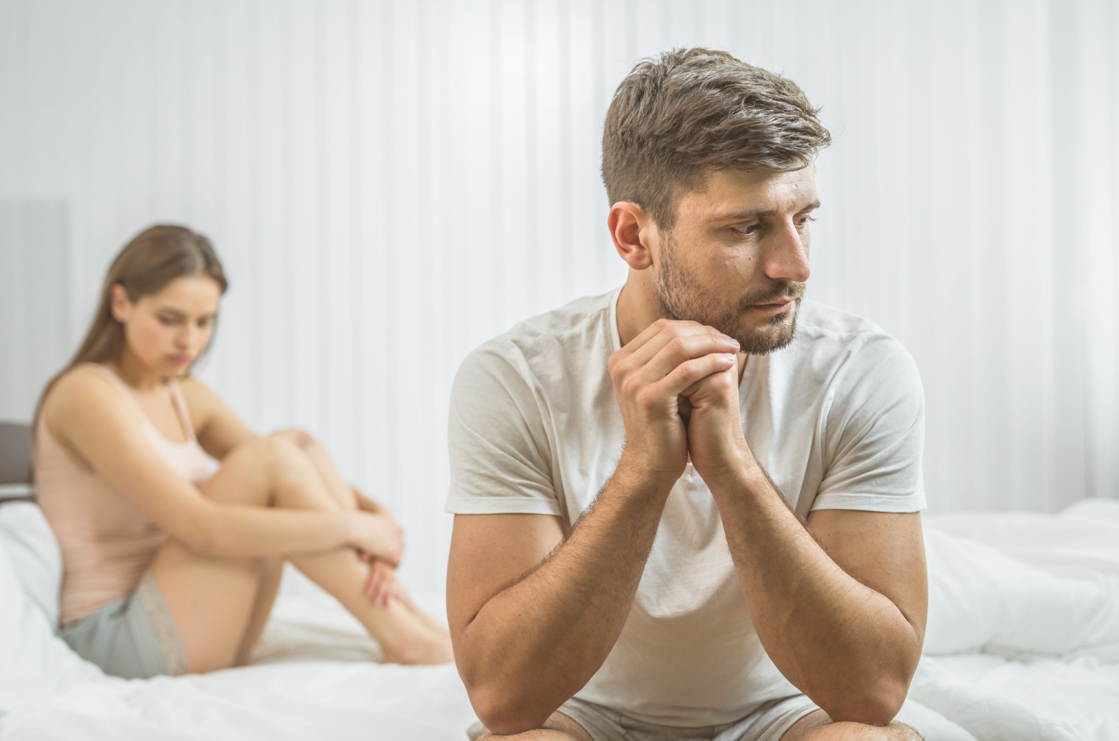 trauriger Mann in der Naehe einer Frau