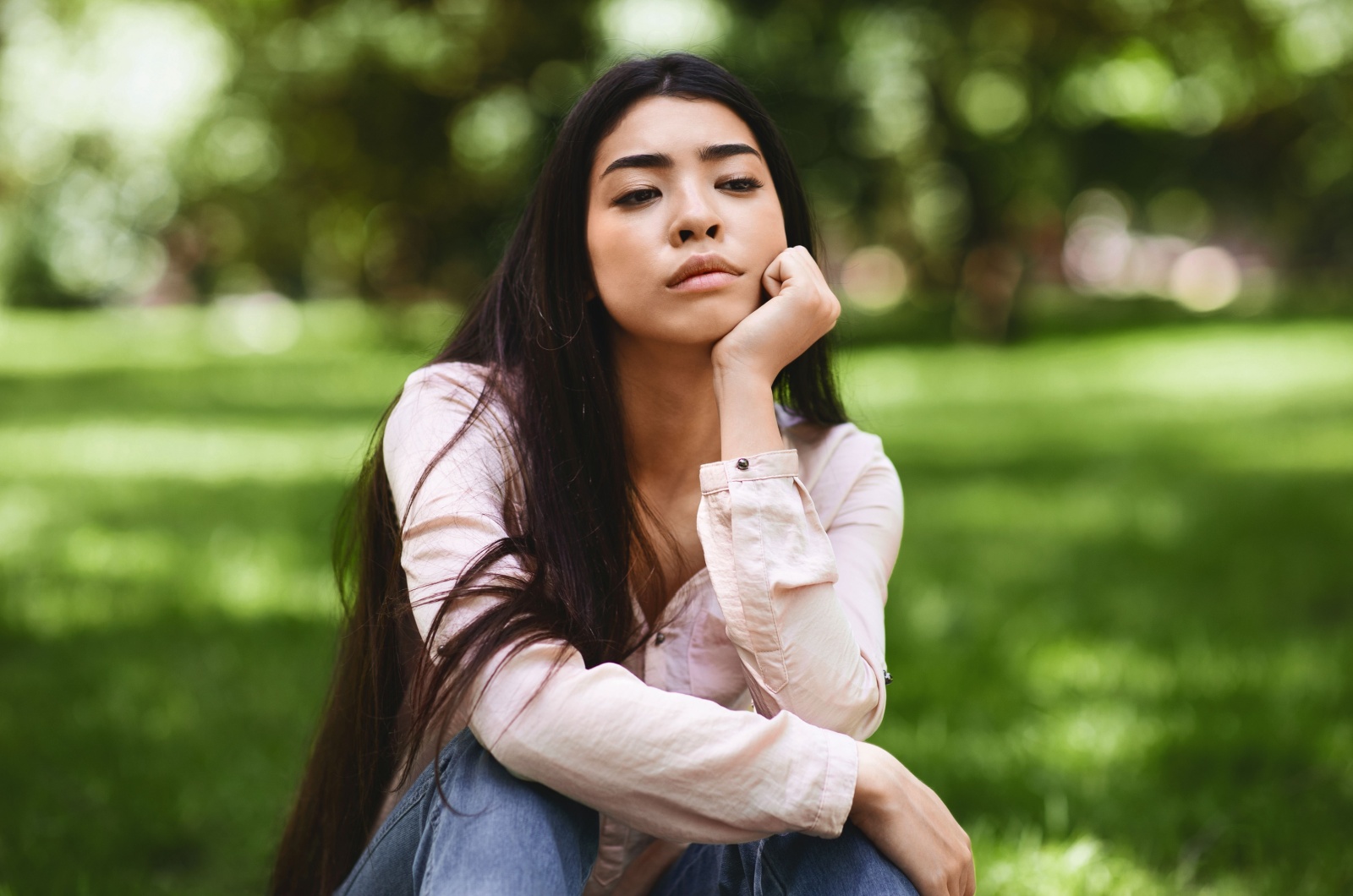 junge frau sitzt auf gras