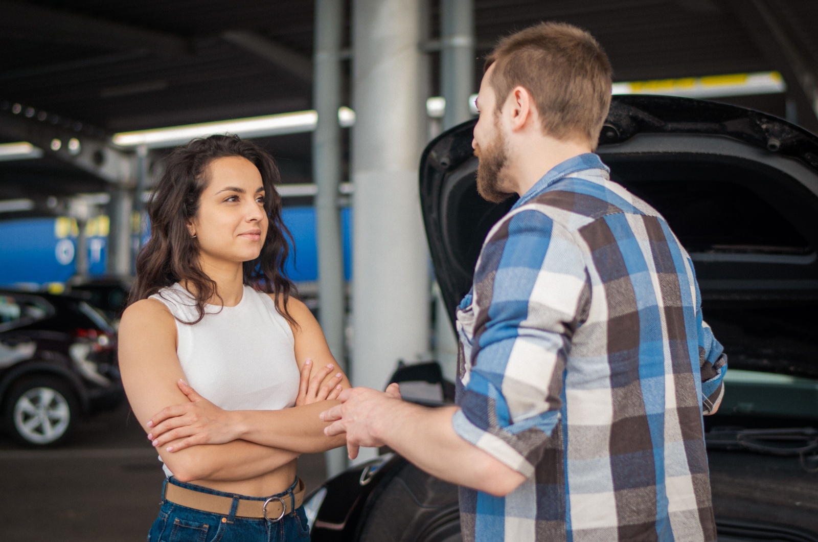 mann und frau reden neben auto