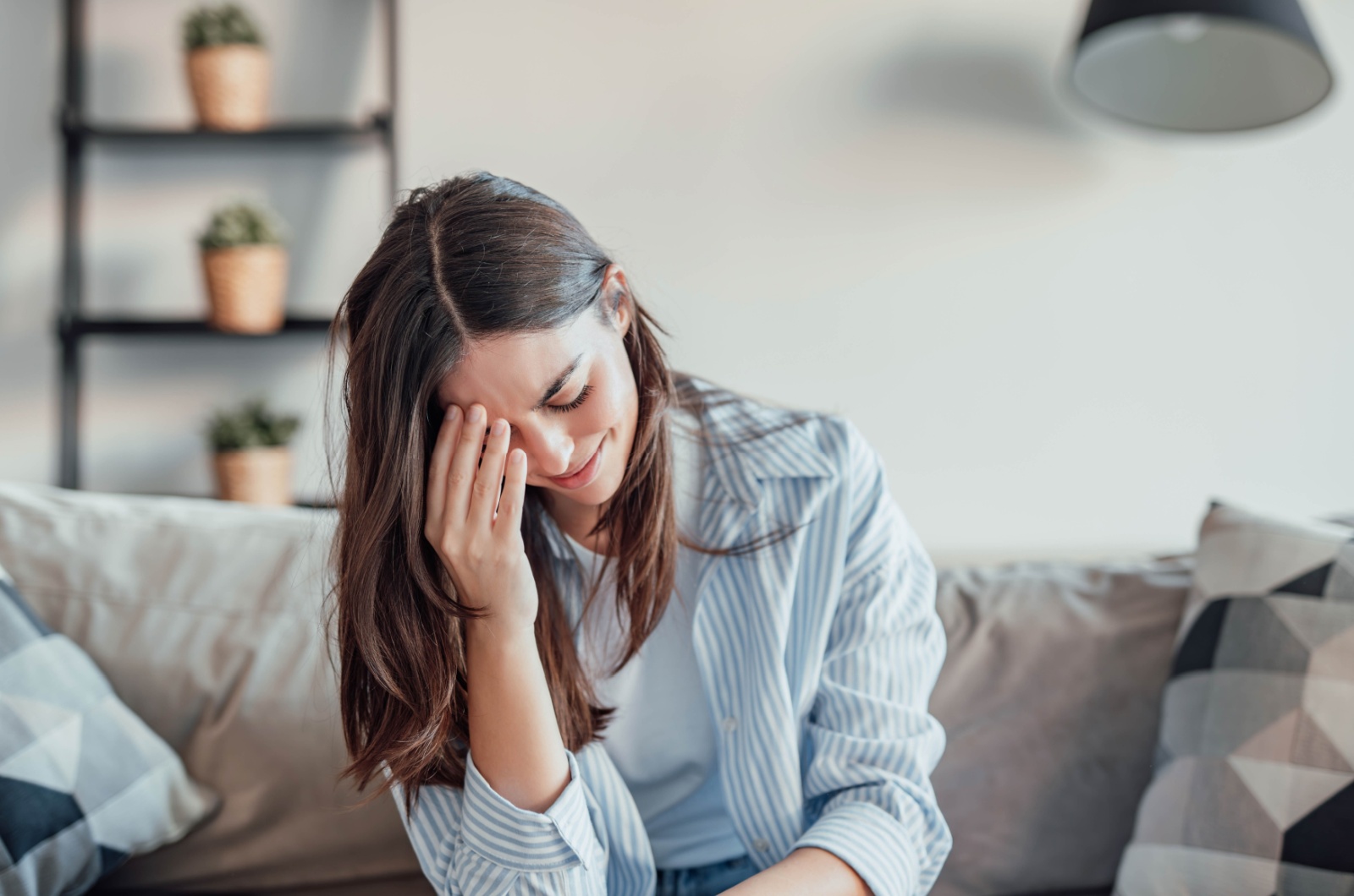 zweifelnde traurige frau sitzt auf sofa