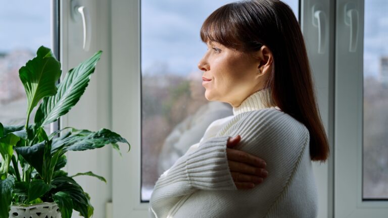 frau denkt nach und sieht aus dem fenster heraus