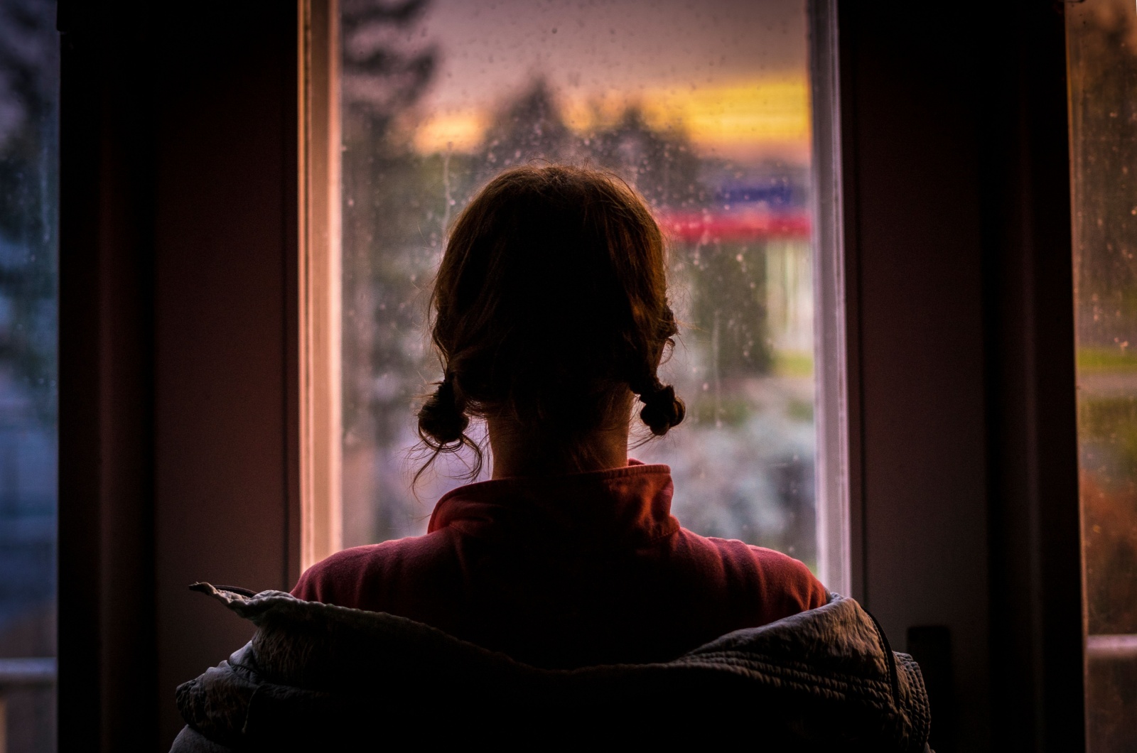 frau schaut aus fenster