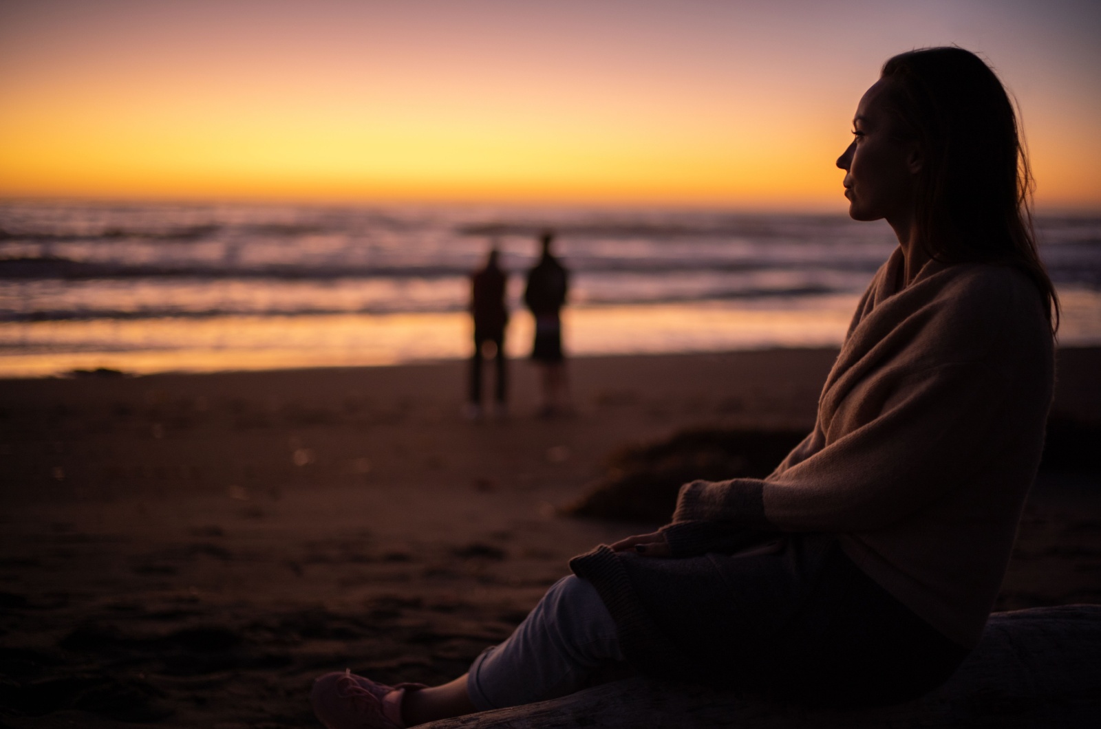 frau sitzt alleine am strand
