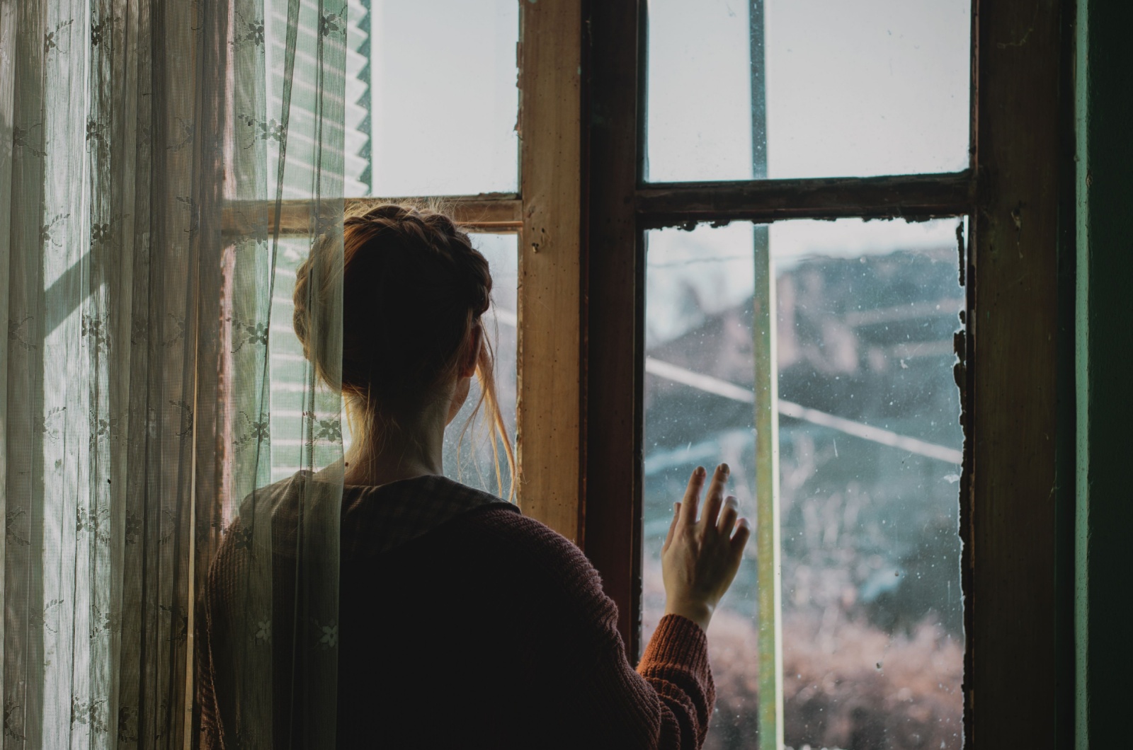 junge frau schaut aus fenster