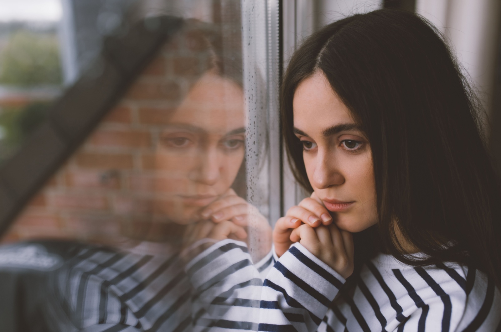junge frau steht am fenster