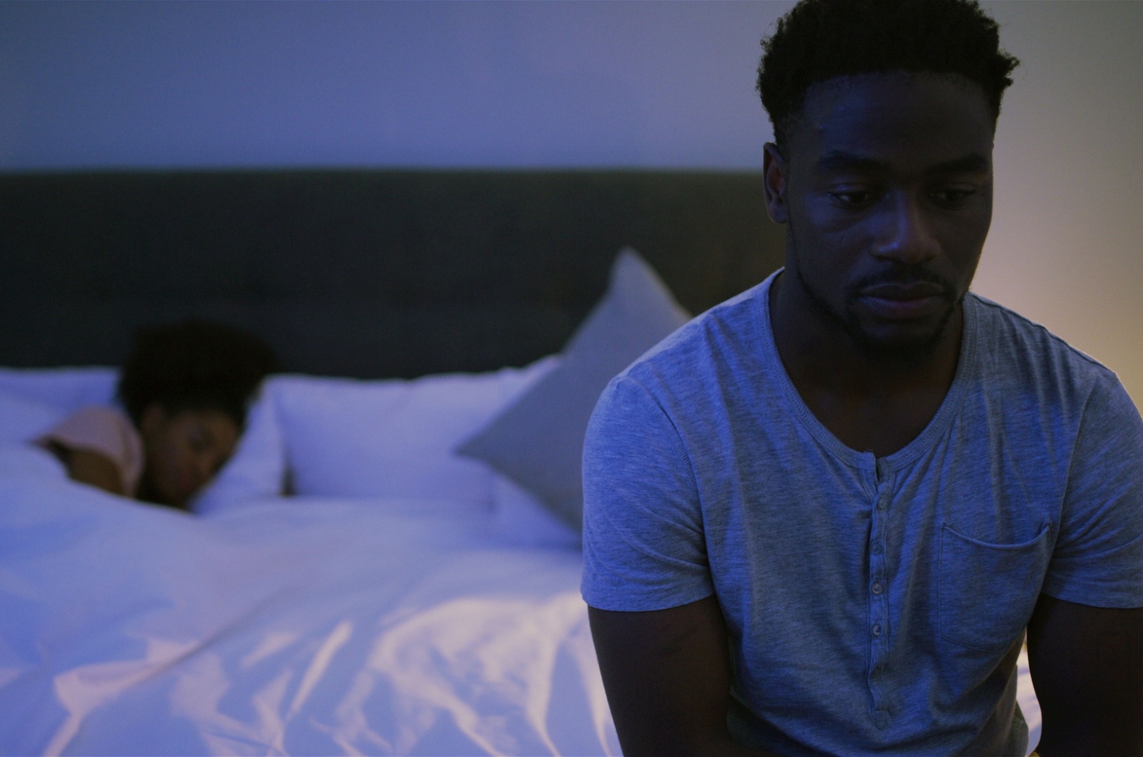 trauriger mann am bett