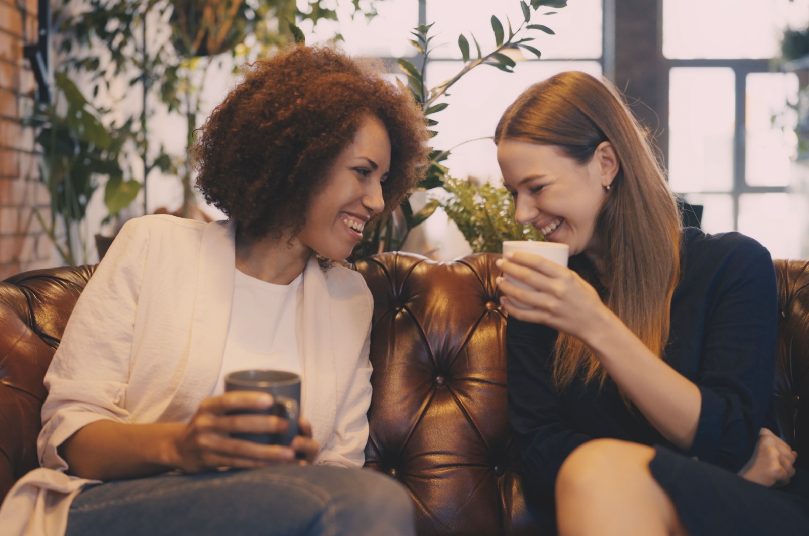 zwei freundinnen trinken kaffe und lachen
