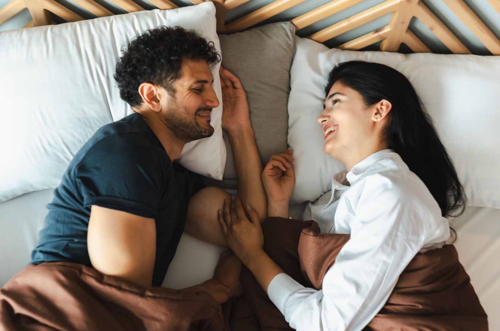 paar lacht zusammen im bett