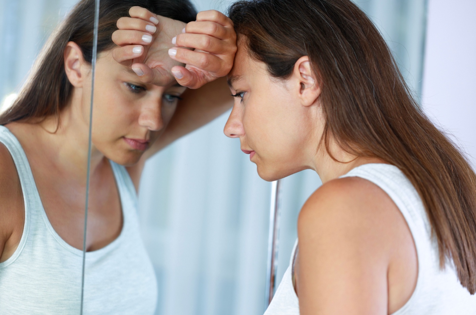 traurige frau schaut in spiegel