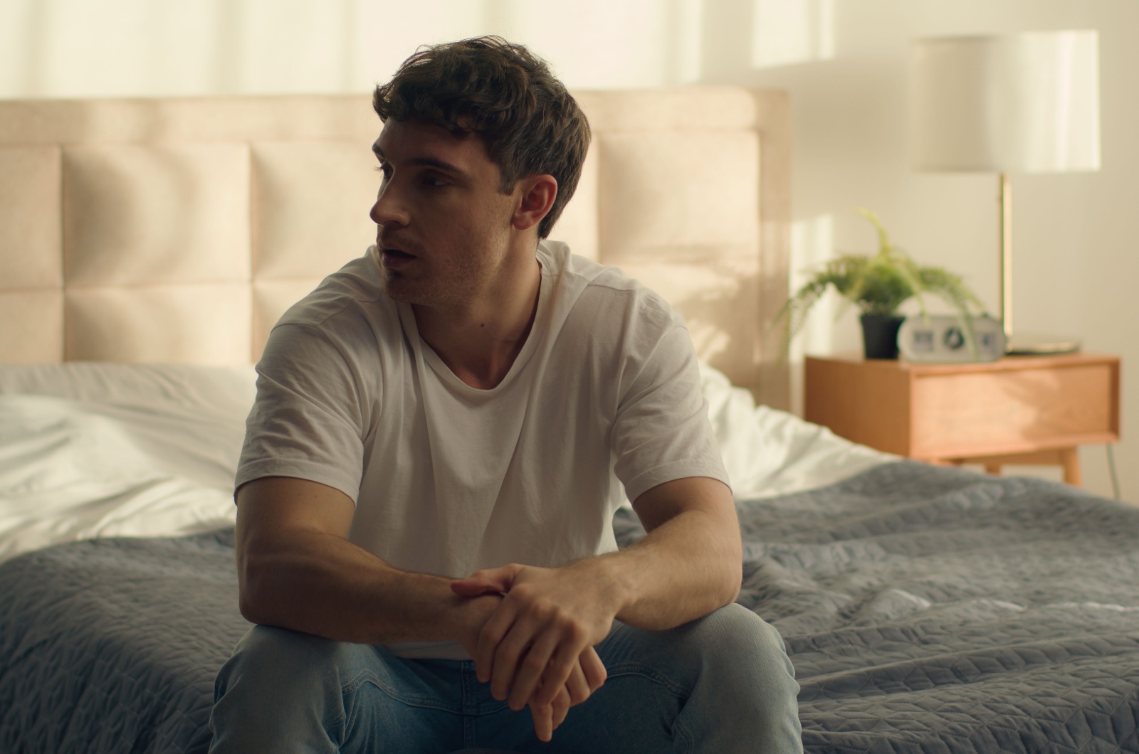 trauriger mann sitzt auf dem bett