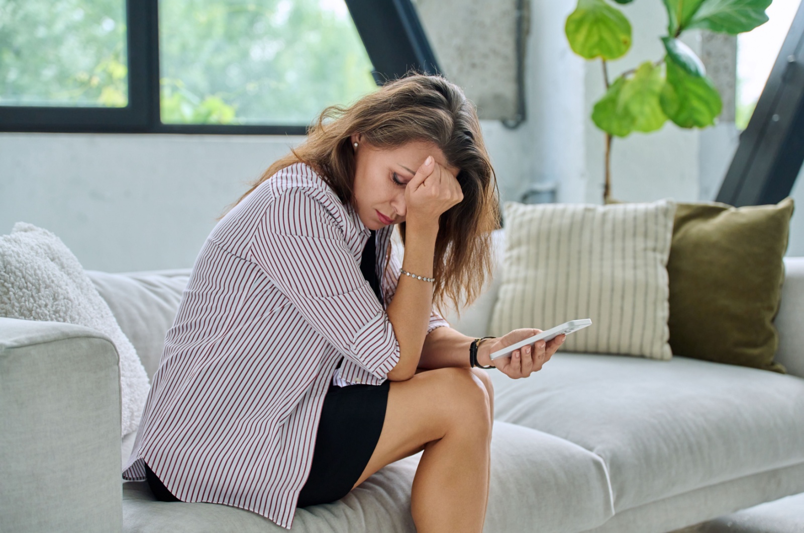 erschoepfte frau mit handy in hand