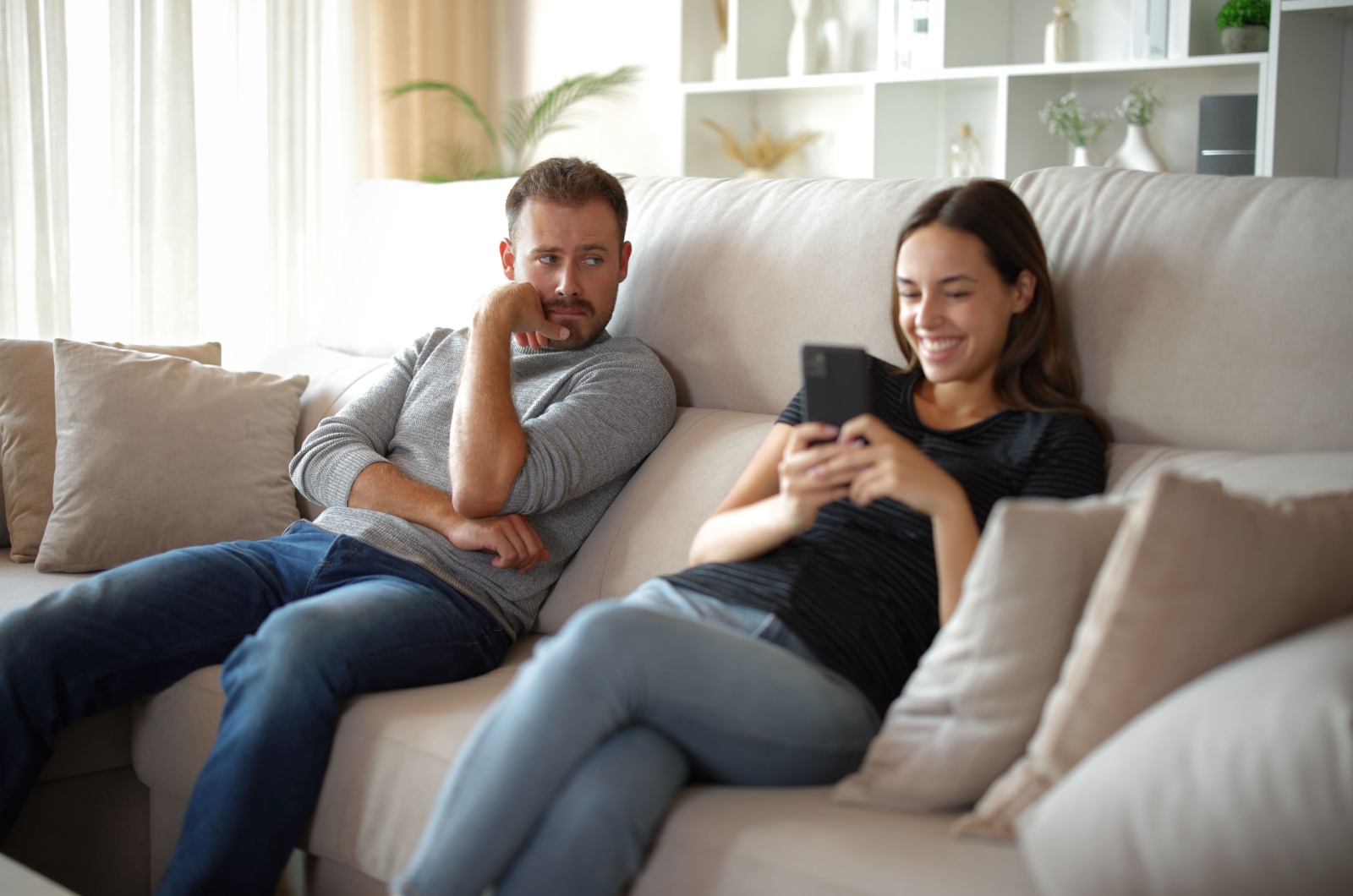 mann blickt zur frau am handy