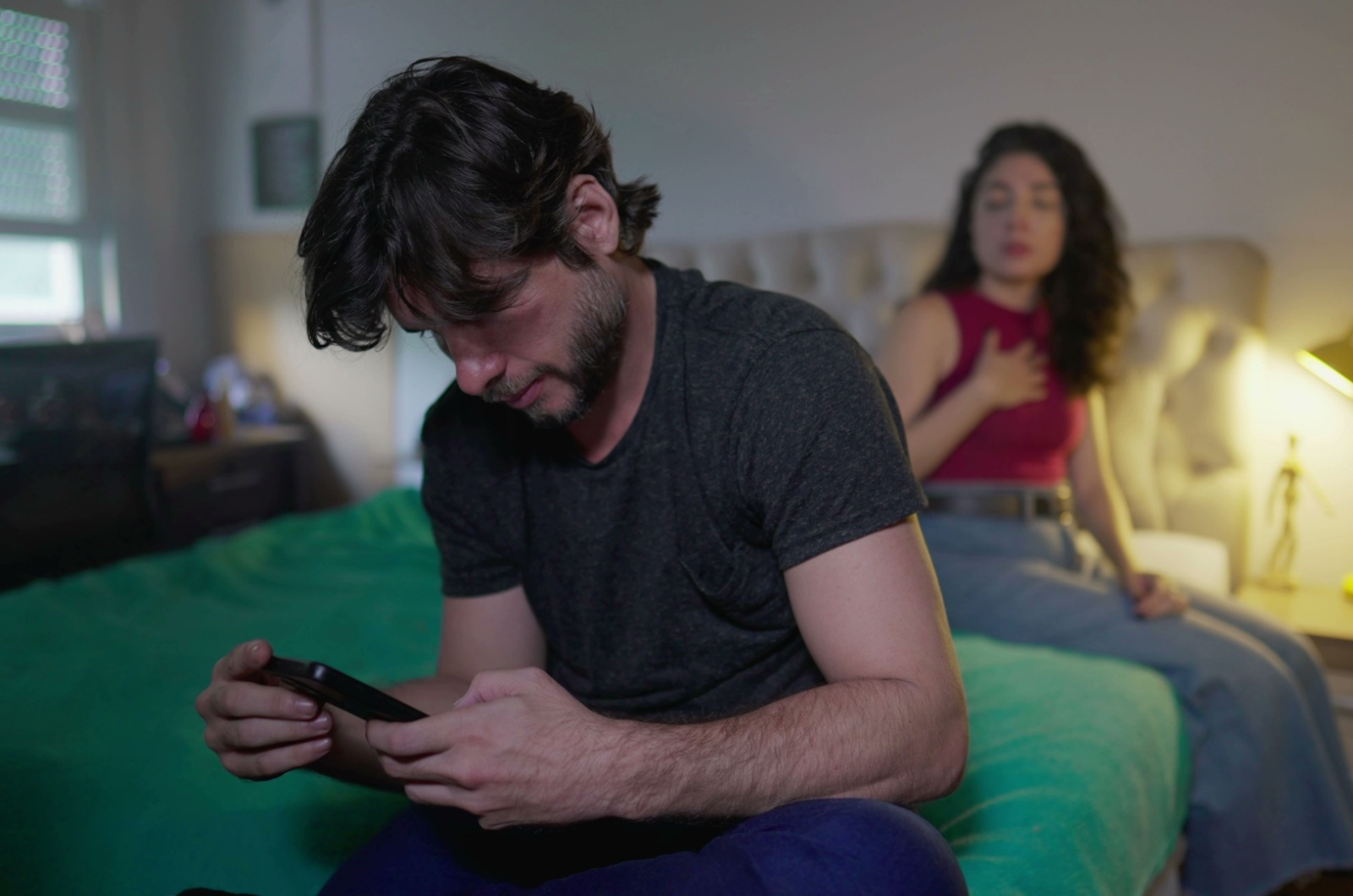 mann mit handy und frau im hintergrund