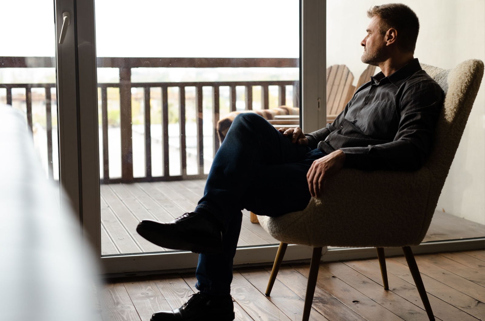 mann sitzt alleine vor einem fenster