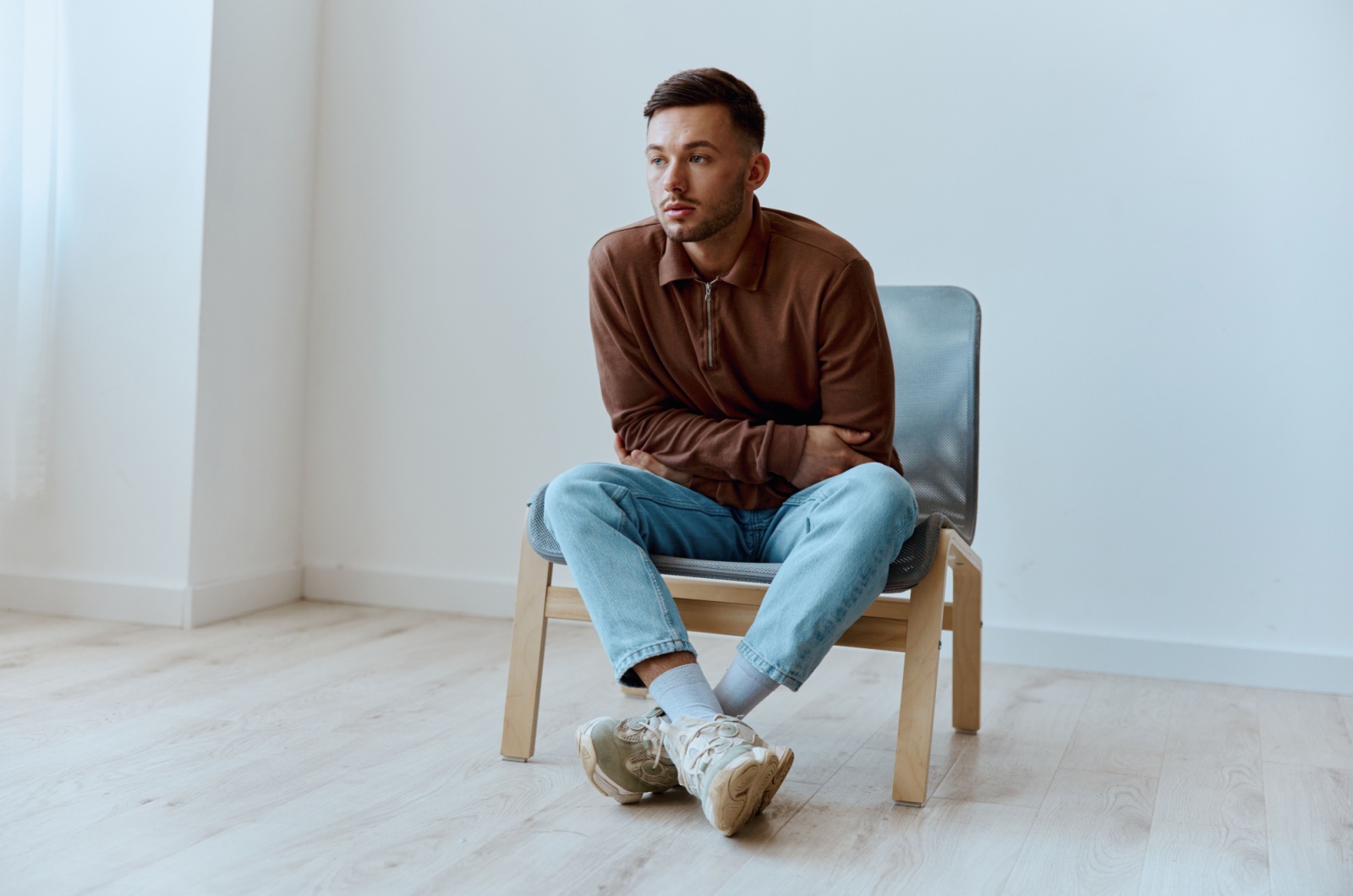 mann sitzt auf einem stuhl alleine