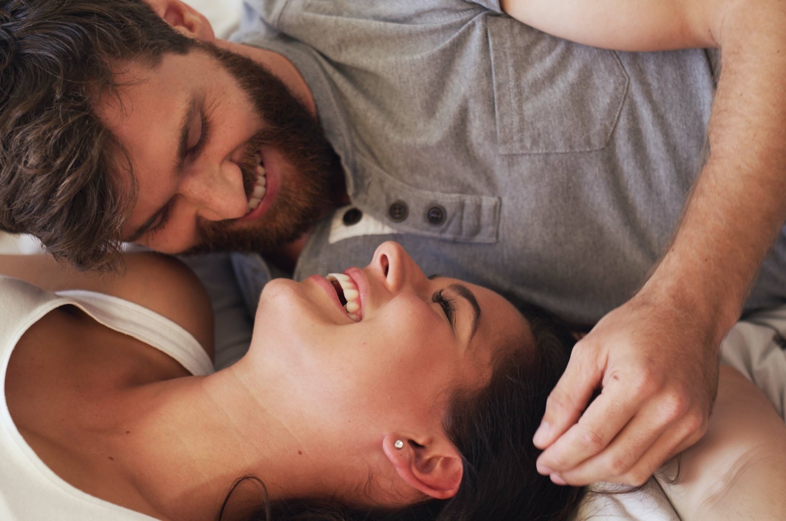 mann und frau lachen auf dem bett