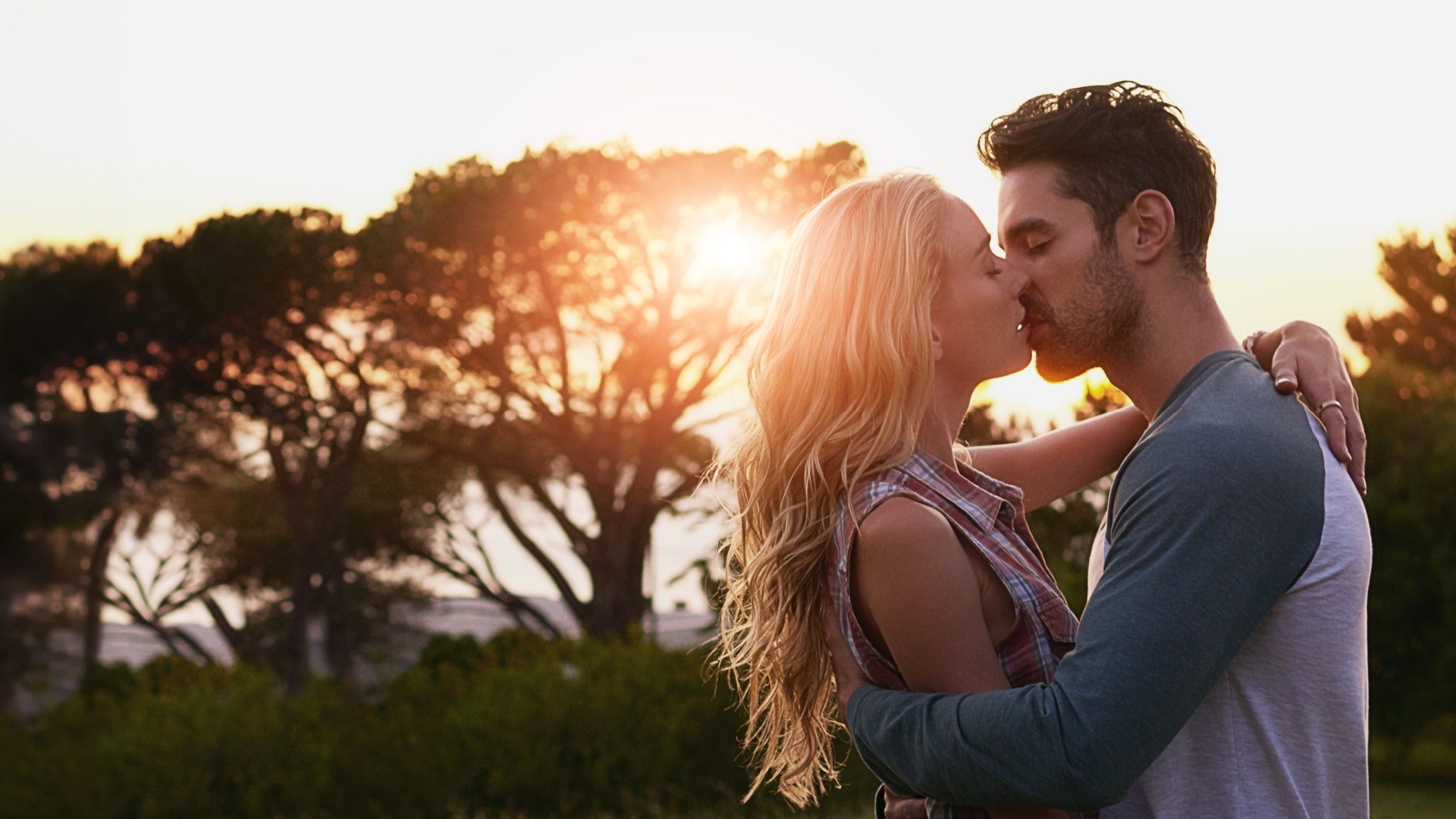 paar kuesst sich im sonnenuntergang