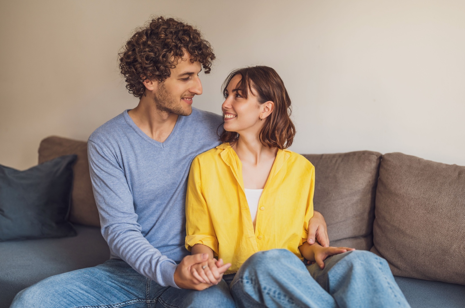 paar sitzt auf dem sofa und sieht sich verliebt an