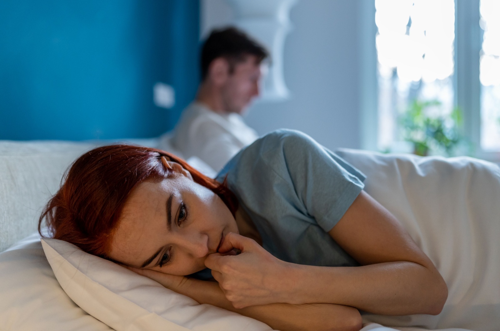 traurige frau liegt im bett neben mann