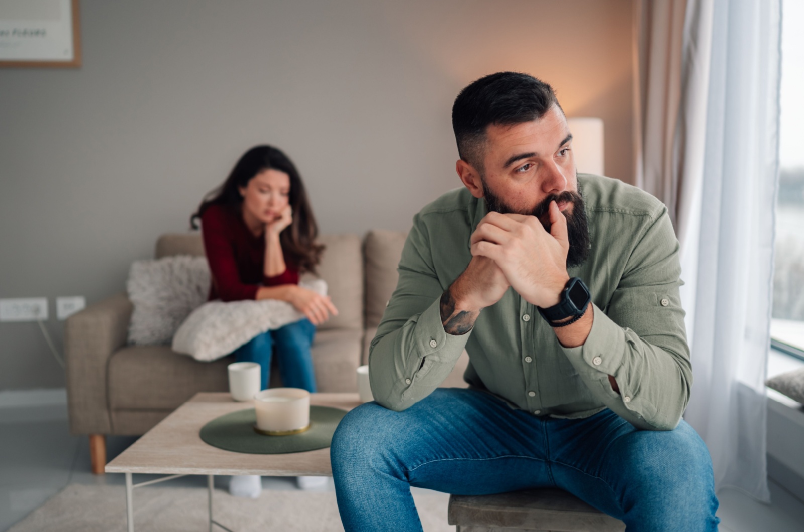 traurige frau sitzt hinter ihrem mann