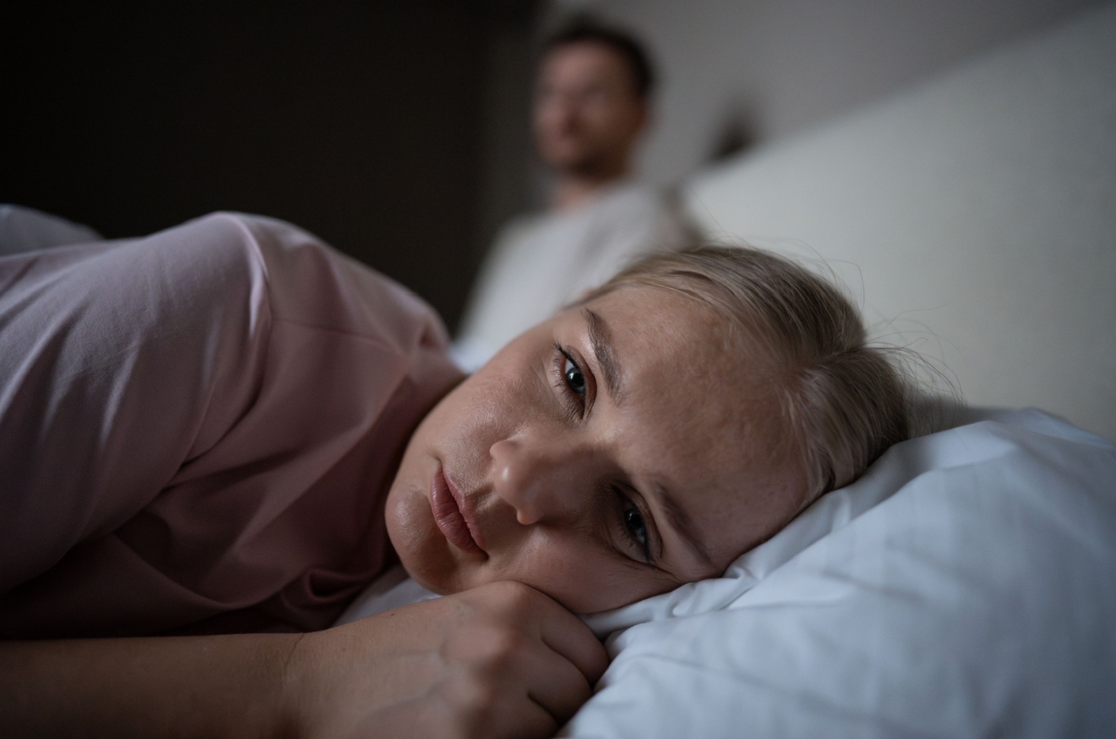 verletzte frau liegt im bett und weint