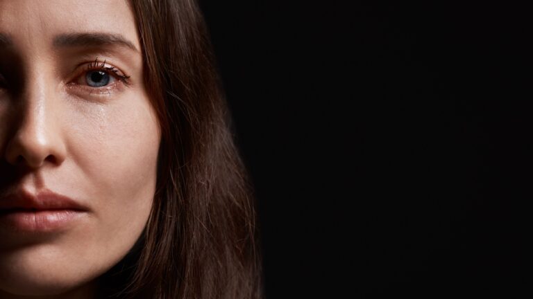 frau zeigt halbes gesicht