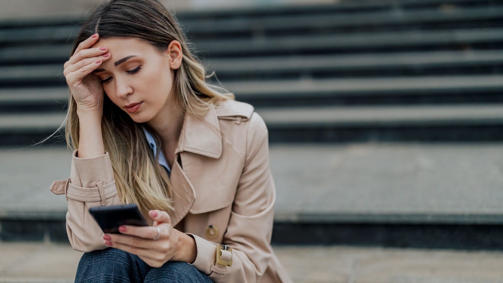 traurige frau mit handy in der hand