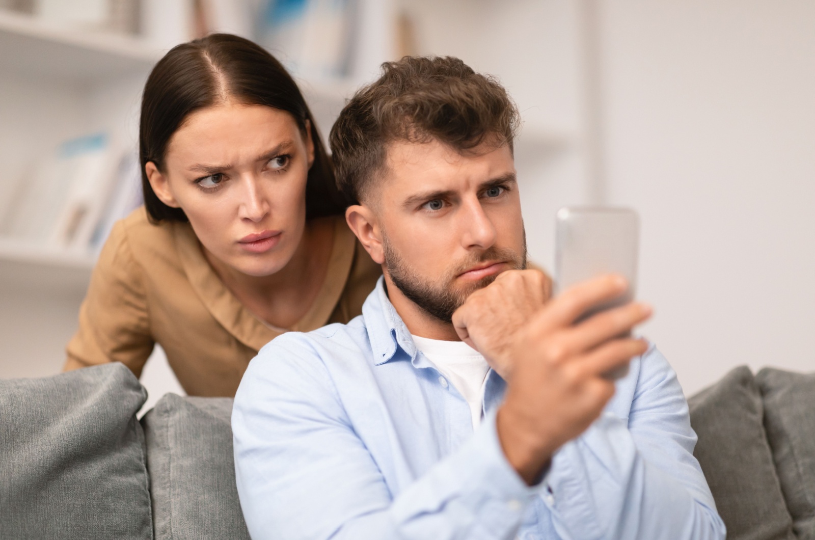 frau schaut auf handy vom mann