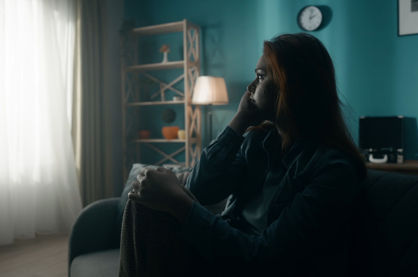 frau sitzt alleine traurig