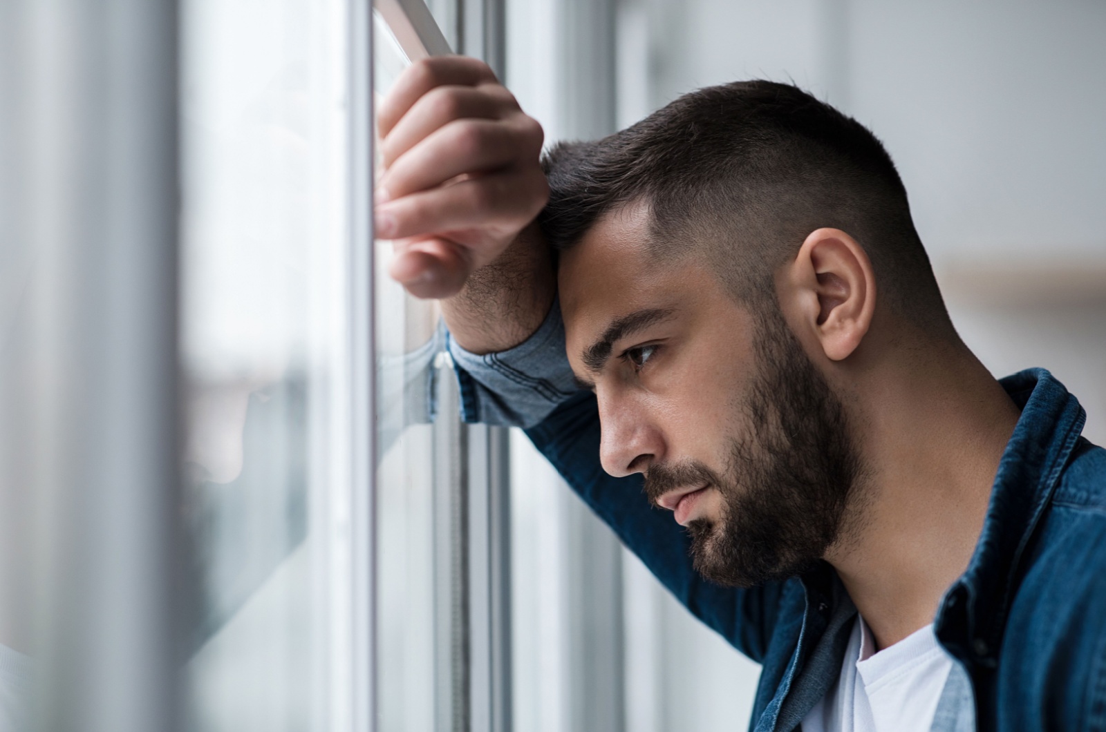 mann schaut aus dem fenster