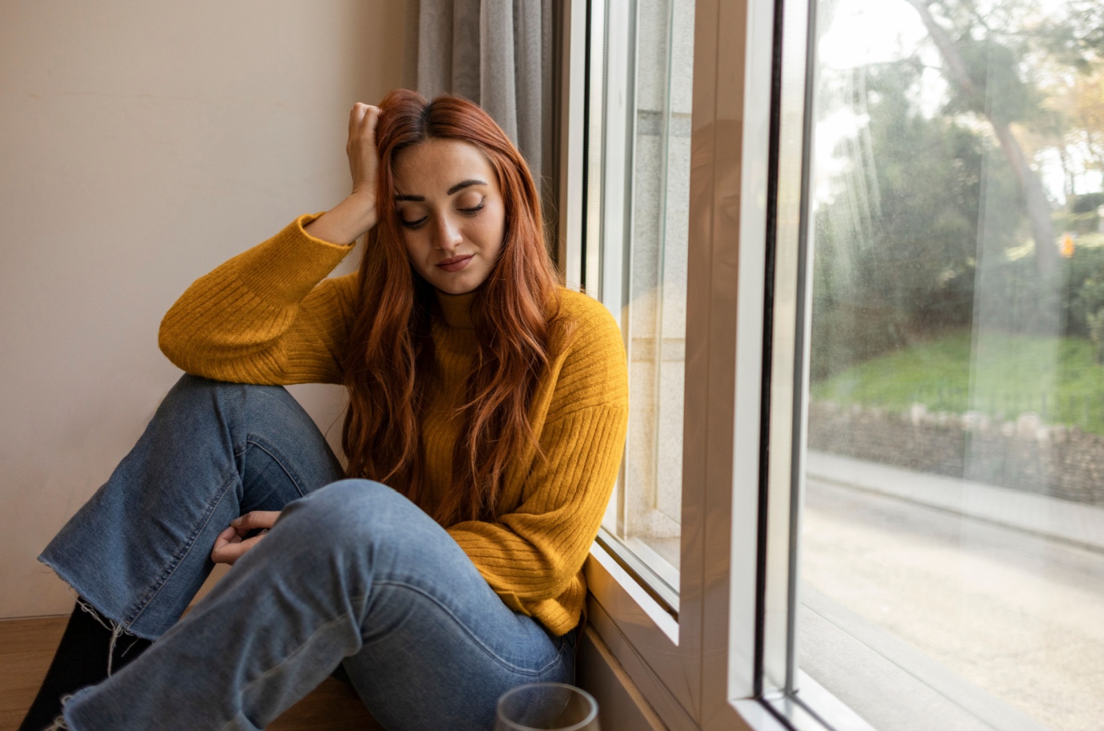 traurige frau sitzt am fenster