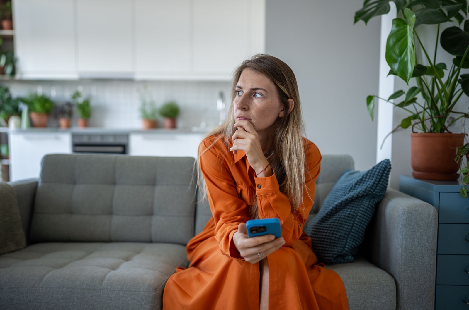 frau im kleid sitzt auf sofa