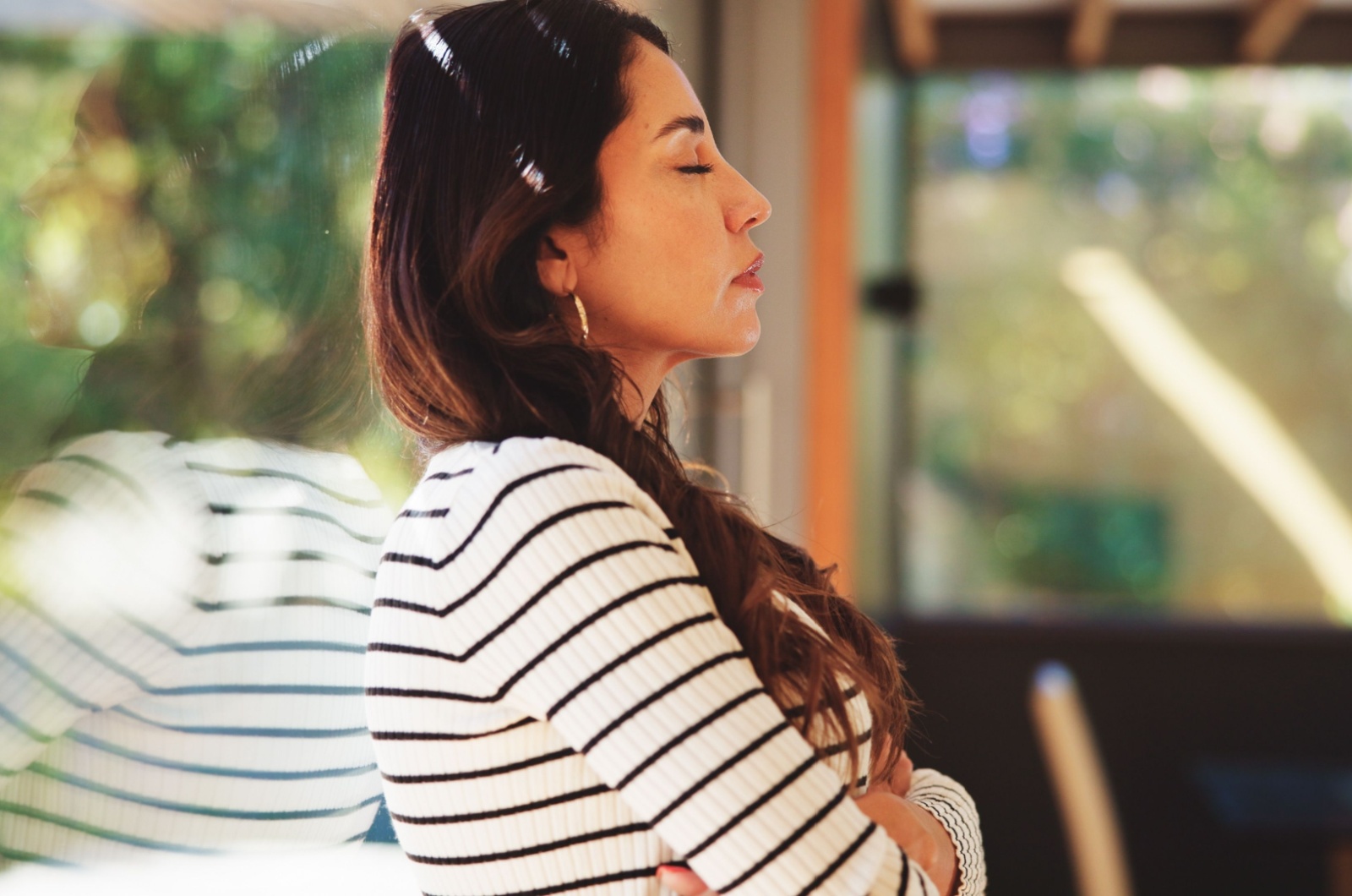 frau lehnt sich an fenster an