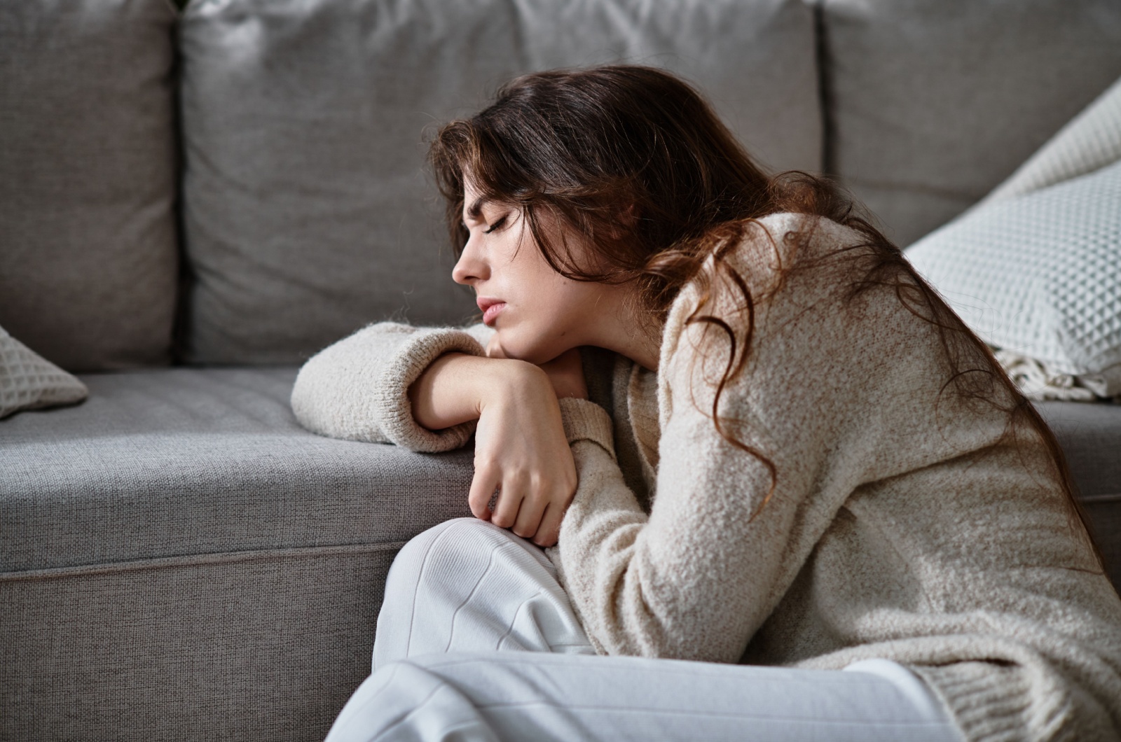 frau lehnt sich an sofa an