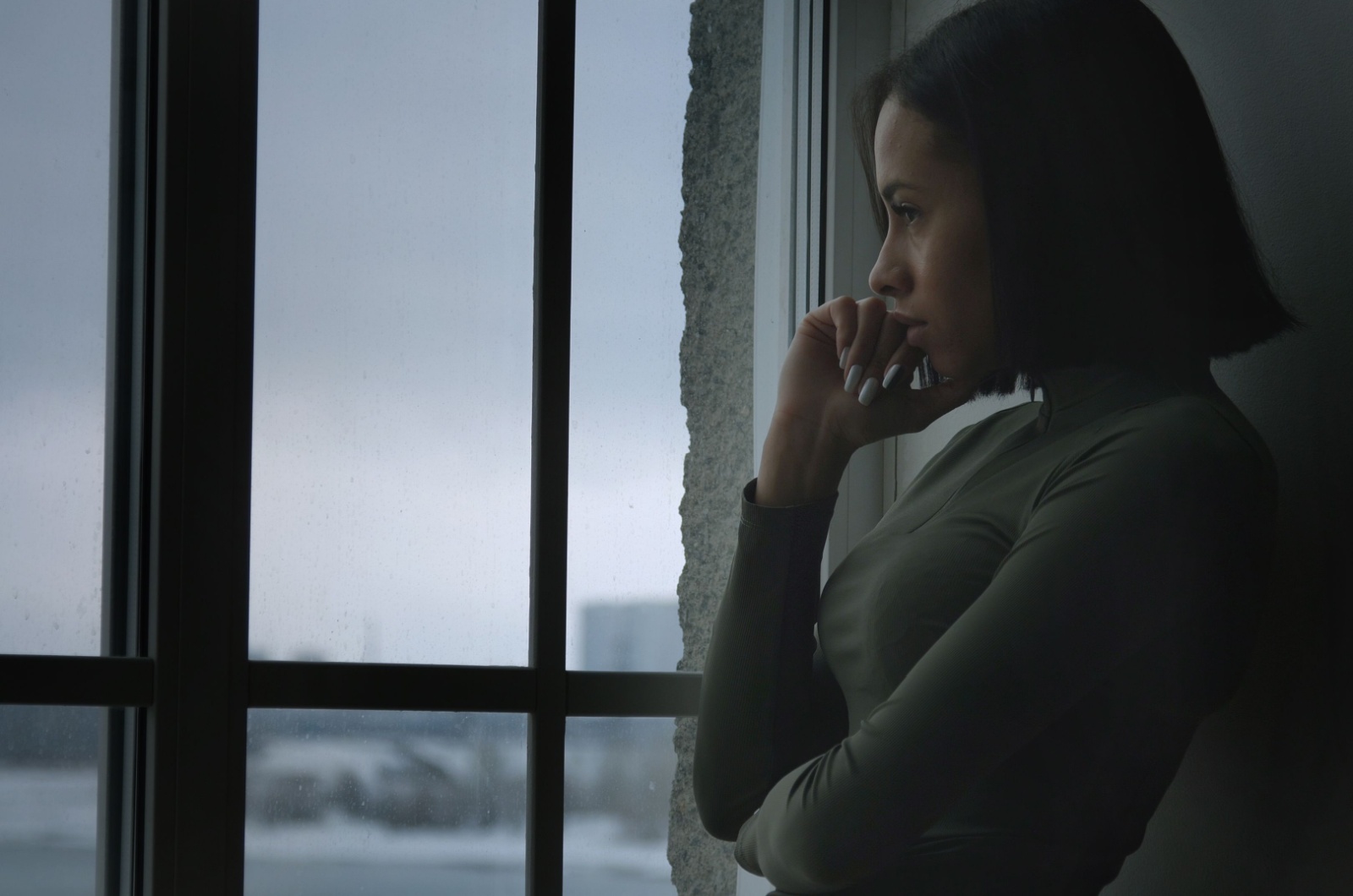 frau nachdenklich neben dem fenster