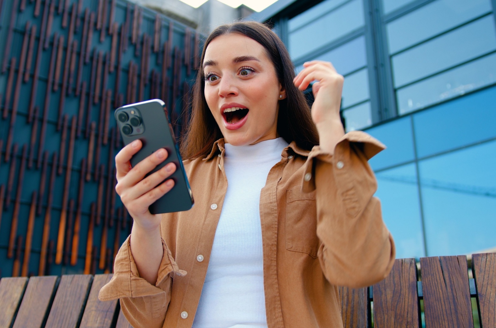 frau sieht auf handy ueberrascht