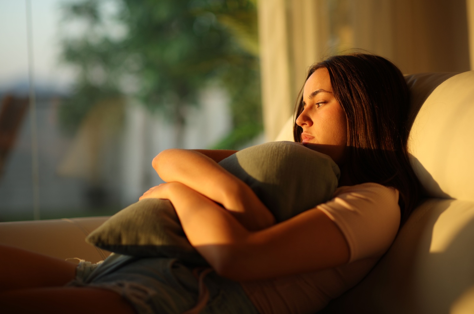 frau umarmt kissen traurig