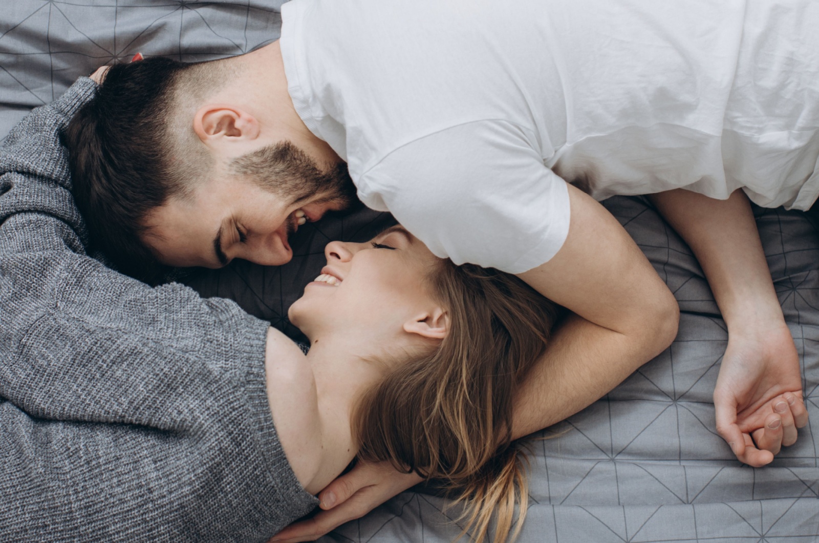 paar lacht im bett