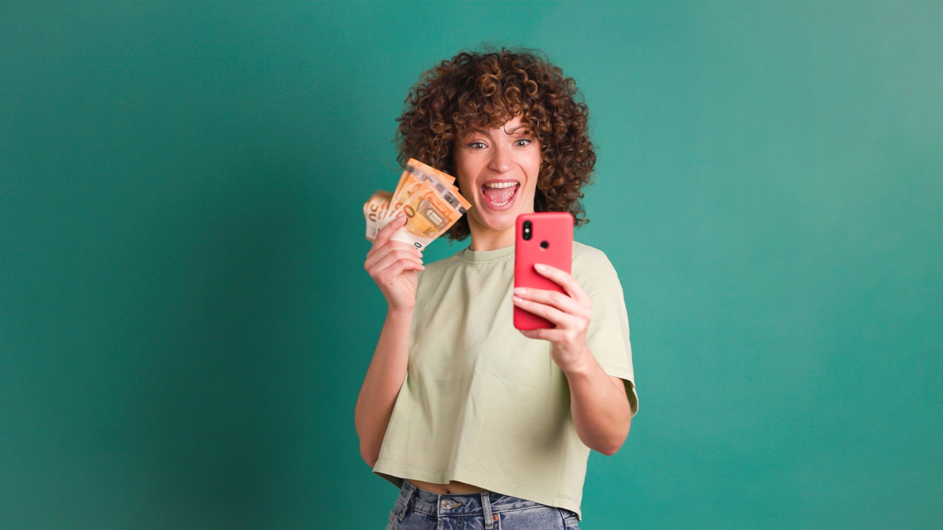 frau mit geld und handy in der hand