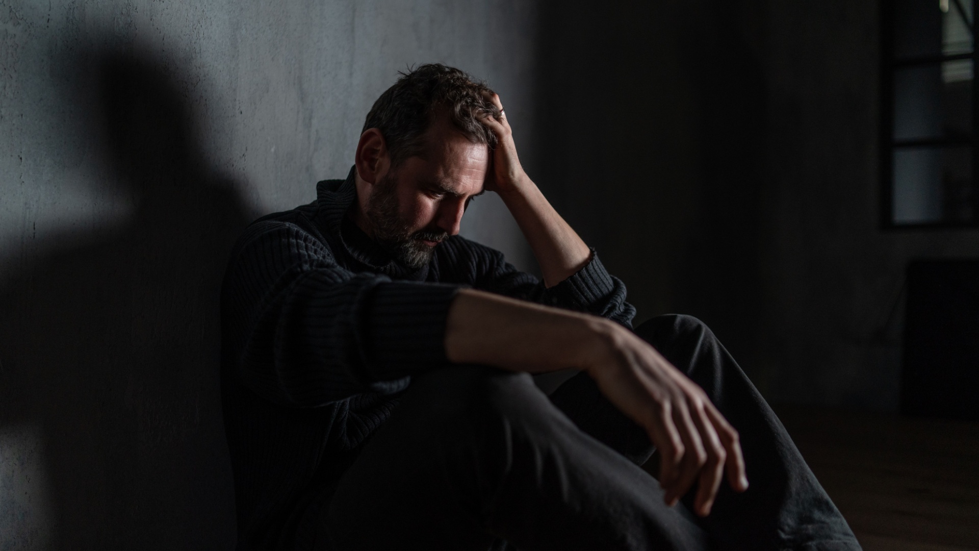 mann im dunklen raum alleine