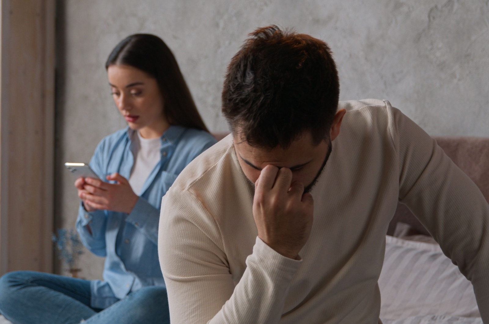 frau am handy neben wuetenden mann