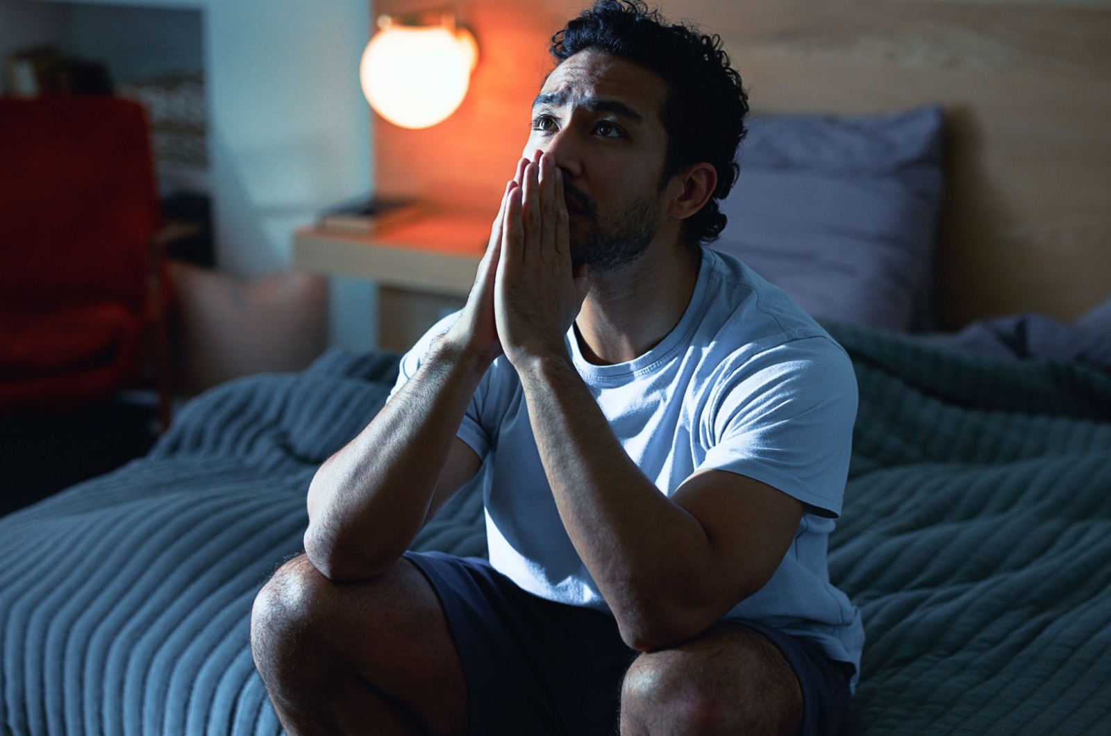 mann sitzt auf bett traurig